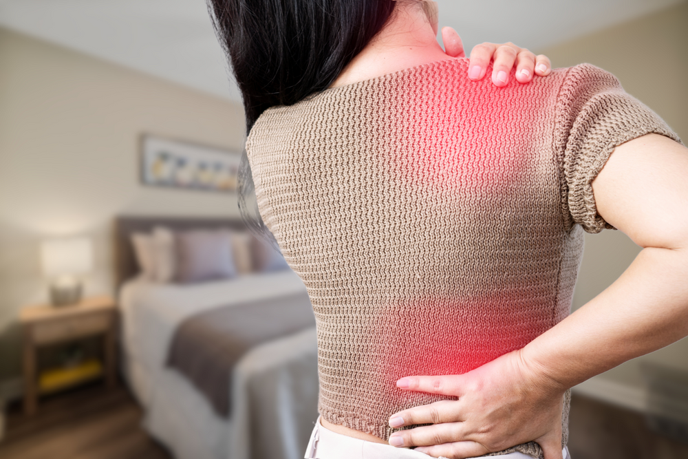 A woman experiencing back pain (highlighted in red).