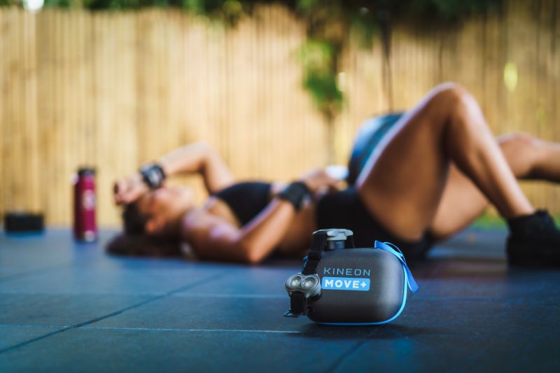 Woman lay down after arthritis exercise routine. The red light therapy is in the foreground of the image.