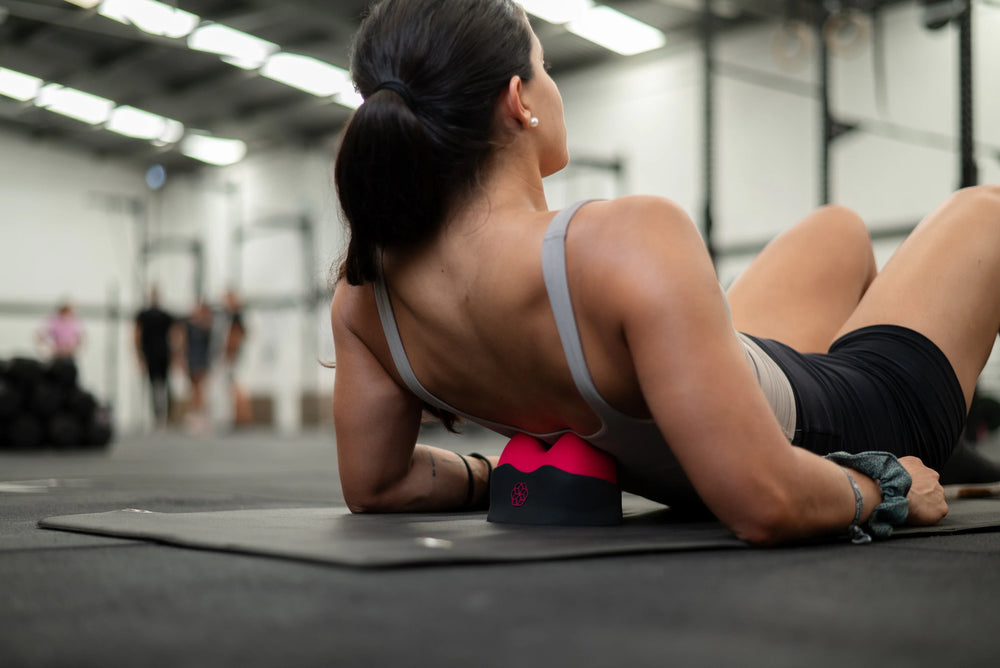 Woman using relief+ a myofascial device on her back to target trigger points