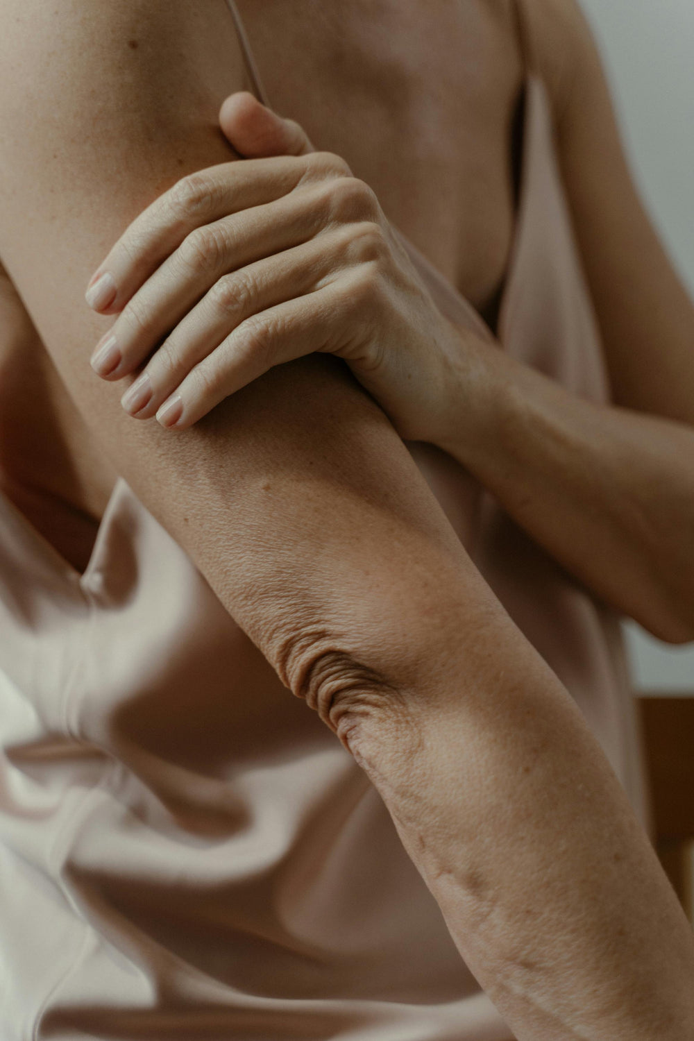 A woman touching her elbow.