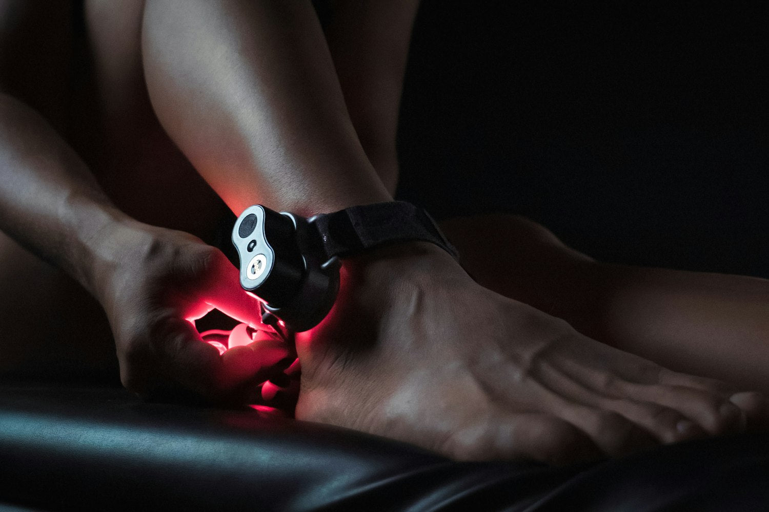 Image of a red light therapy device on a woman's ankle.