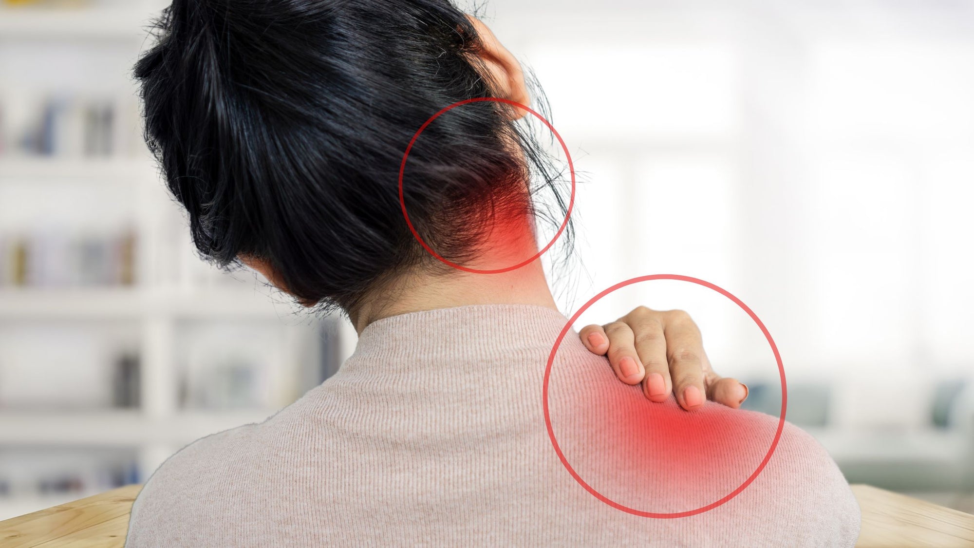 Image of a woman in her living room struggling with neck and shoulder pain.