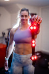 A woman showing of Kineon's Move + red light therapy device.